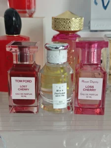 Optischer und chemischer Vergleich: Teurer Luxus-Kirschduft im Flakon neben einer hochwertigen Parfum-Alternative mit optimierter Haltbarkeit.